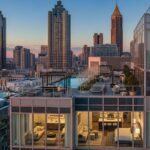 An exterior view of a modern high-rise luxury apartment building in Atlanta at sunset. The building has large windows and a rooftop pool and patio area. The interior of several units is visible, showcasing modern, well-lit living spaces and bedrooms. The Atlanta skyline is visible in the background.