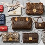 An overhead flat lay of various iconic luxury handbags, including quilted Chanel flaps in red, white, and navy, a Louis Vuitton Monogram Speedy, a Louis Vuitton Monogram wallet on chain, a black pebbled leather bag, and tweed/snakeskin patterned bags, all on a gray blanket.