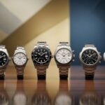 A line of six luxury men's watches on metal bracelets, alternating between black and white dials, with visible brand elements like chronographs and dive bezels, set on a wooden surface against an abstract background.