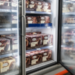 ext: Costco freezer doors stocked floor-to-ceiling with boxes of Dubai Style Chocolate Mini Bars labeled as the Häagen-Dazs Costco exclusive flavor, with a “LIMITED RELEASE” shelf tag visible to shoppers.